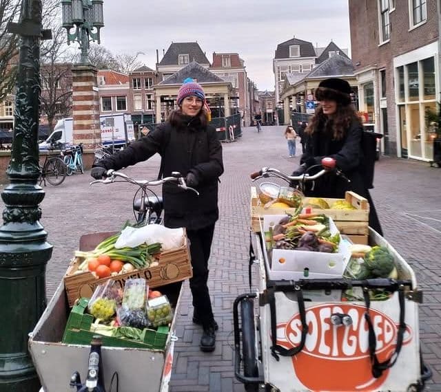Het soepgoed team op de markt met bakfietsen vol groente en fruit